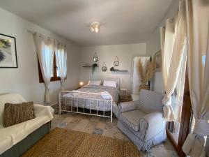 埃帕诺米Sea front Villa Myrat的一间卧室配有一张床、一张沙发和一把椅子