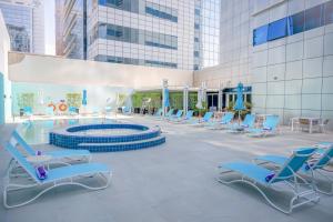 阿布扎比阿布扎比首都中心高级宾馆的一组椅子和一个游泳池
