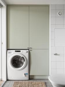 哥德堡Waterfront Cabins的白色浴室内的洗衣机和烘干机