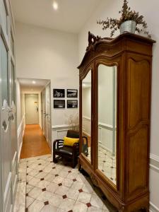 普罗旺斯艾克斯Les Suites du Cours & Spa的客房设有带镜子的大型木制橱柜