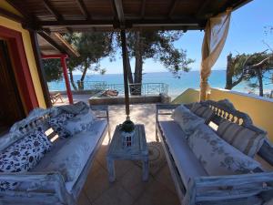 埃帕诺米Sea front Villa Myrat的一个带两张沙发和一张桌子的门廊