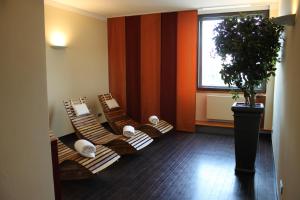 斯图加特施泰根博阁格拉夫齐柏林酒店的一间房间,配有三把棕色椅子和盆栽植物