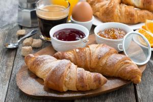 不莱梅不来梅H5+酒店的一张带羊角面包和其他早餐食品的木桌