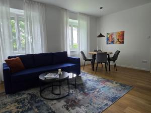 因河畔布劳瑙Central stylish apartment的客厅配有蓝色的沙发和桌子
