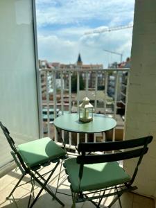 克诺克－海斯特Appartement Seaview Bunnenplein的阳台上的一张桌子和两把椅子,上面有蜡烛