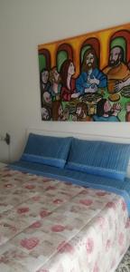 阿斯蒂Casa arcobaleno的卧室内的一张床铺,墙上有绘画作品