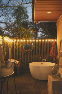 西归浦市Entire House with Garden - Warm water Jacuzzi的庭院设有浴缸,在栅栏上灯火通明