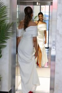 多布拉沃达Baba's Hotel & Spa的穿白色衣服的女人,穿镜子