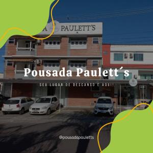 伊列乌斯Pousada Paulett's - Hospedagem na Zona Norte de Ilhéus - Bahia的停车场内有车辆的建筑物