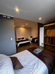 奥索尔诺Hotel Mackenna的一间设有两张床的酒店客房和一间设有两张床的客房