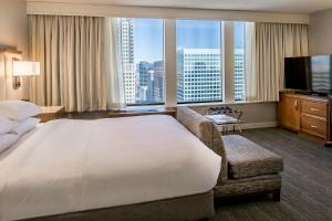 圣路易斯圣路易斯球场希尔顿酒店的一间酒店客房,设有一张大床和一个大窗户