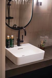 哥德堡Clarion Hotel Karlatornet的浴室设有白色水槽和镜子