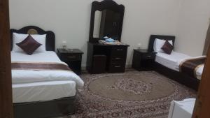 Al Nairyahالعييري للشقق المفروشة االنعيريه 1的一间卧室配有两张床、镜子和地毯