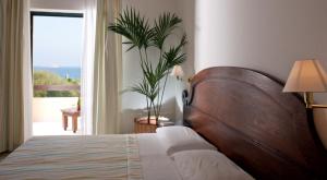 圣玛丽亚纳瓦雷地中海酒店的一间卧室配有一张床和一个植物窗户