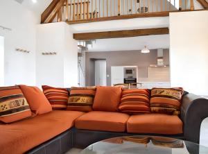 LevrouxMaison de 5 chambres avec jacuzzi jardin clos et wifi a Levroux的客厅里配有带枕头的橙色沙发