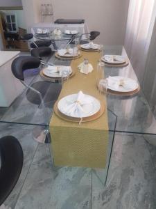 伯诺尼Zurich Garden Hotel的玻璃桌,上面有盘子和餐巾
