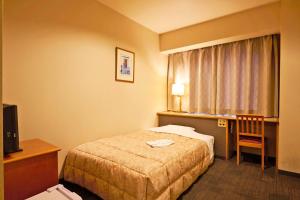 上尾市上尾东武酒店 的配有一张床、一张书桌和一扇窗户的酒店客房