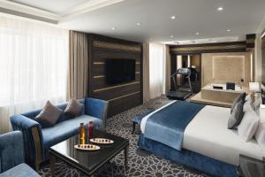 布赖代卡西姆瑞享酒店的酒店客房设有一张大床和一张沙发。