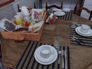 乌鲁比西Pousada Caminhos do Mel - Urubici - SC的一张带白板和食物箱的木桌