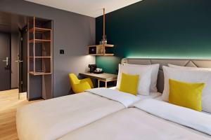 因特拉肯Essential by Dorint Interlaken - New Opening的一间卧室设有一张床和绿色的墙壁