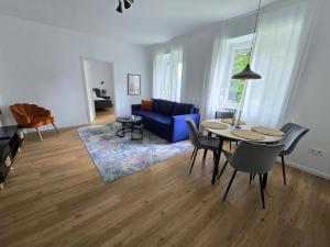 因河畔布劳瑙Central stylish apartment的客厅配有桌子和蓝色沙发