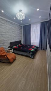 卡拉甘达Апартаменты в ЖК Мерей的一间卧室配有一张大床和一个吊灯。
