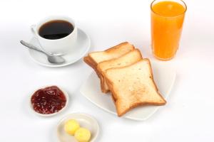 钦博特Paris Senlis Hostel Plus的白桌,带一盘烤面包和一杯咖啡