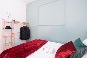都灵Maison Métropole Turin的一间卧室配有一张带红色床单的床和衣架