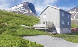 FjordgårdSegla Guesthouse - with view of Fjord的山边的山丘上的房子