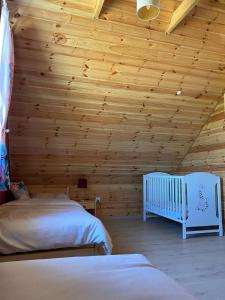 卢巴夫卡Leśna Ostoja的一间卧室配有两张床和一张婴儿床。