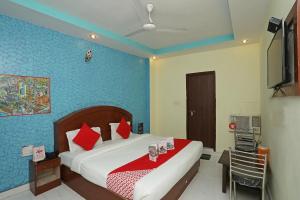 哈里瓦Flagship Hotel Neel Ganga的一间卧室配有一张带红色枕头的大床