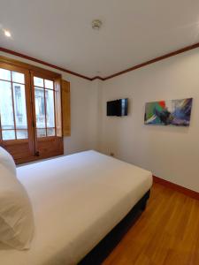 圣地亚哥Concha y Toro 33 Hotel Boutique by Nobile的卧室配有一张白色大床和电视。