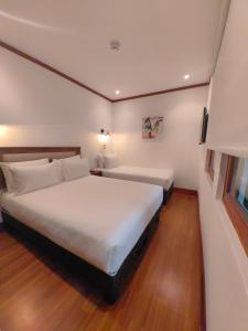 圣地亚哥Concha y Toro 33 Hotel Boutique by Nobile的卧室配有一张白色的大床,铺有木地板