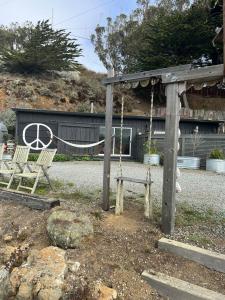 MarshallCarriage House Waterfront On Tomales Bay With Dock的一个带两把椅子和秋千的游乐场