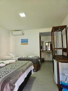蜜岛Pousada Villa Encantada Ilha do Mel的酒店客房,设有两张床和镜子