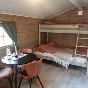 PotkaTørfoss Gård, Hytte utleie, Campingvogn og bobil plasser的卧室配有两张双层床和一张桌子及椅子