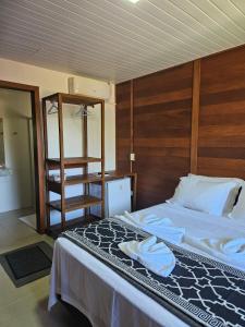 蜜岛Pousada Villa Encantada Ilha do Mel的一间卧室配有一张带木制床头板的床