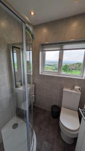 霍姆弗斯Lane End Cottage Holmfirth - Panoramic Views, Modernised with offroad parking的带淋浴和卫生间的浴室以及窗户。