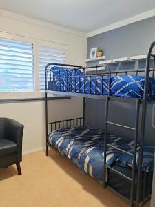 珀斯YouComeAu的一间卧室配有两张双层床和椅子