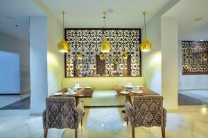 迪巴富吉拉丽笙度假酒店的用餐室设有黄色的沙发、桌子和椅子