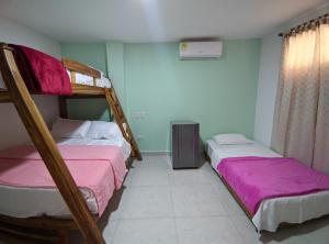 卡塔赫纳Dreimar Hotel Boutique的配有两张双层床的宿舍间配有粉红色床单