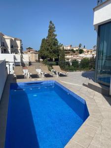 托罗克斯Villa Torre Paraíso的一座带椅子的蓝色游泳池和一座建筑