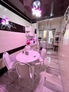 卡拉科尔Komfort Lux Centre Karakol的粉红色的用餐室配有桌椅