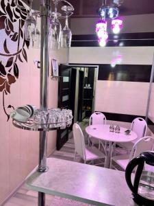 卡拉科尔Komfort Lux Centre Karakol的用餐室配有2张桌子和白色椅子
