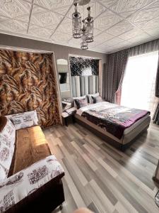 卡拉科尔Komfort Lux Centre Karakol的一间大型卧室,配有两张床和一面墙