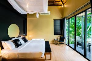 攀瓦海滩The Mangrove by Blu Monkey Phuket的一间卧室设有一张大床和大窗户