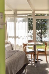霍巴特滨河汽车旅馆别墅酒店的卧室配有一张床和一张桌子及椅子
