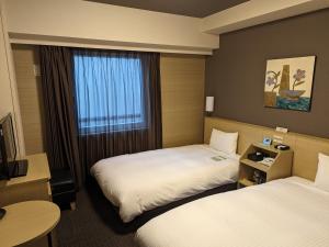Oshu奥什鹿特酒店的酒店客房设有两张床和窗户。