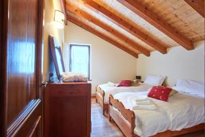 西比纳Lioda Costa的配有木天花板的客房设有两张床。