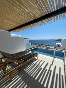 普拉迪斯亚罗斯Seethrough Mykonos Suites的一个带椅子的甲板和一个游泳池
